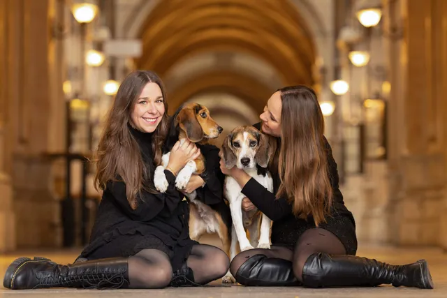 Zwei junge Frauen mit ihren Hunden, schöne Lichter im Hintergrund