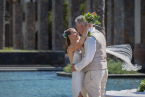Paar umarmt sich und schaut sich gegenseitig in die Augen, Braut hält einen Blumenstrauß in der Hand