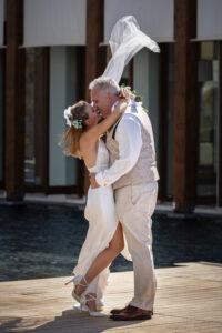 Paar küsst sich während der Hochzeit auf einem kleinen Steg im Wasser