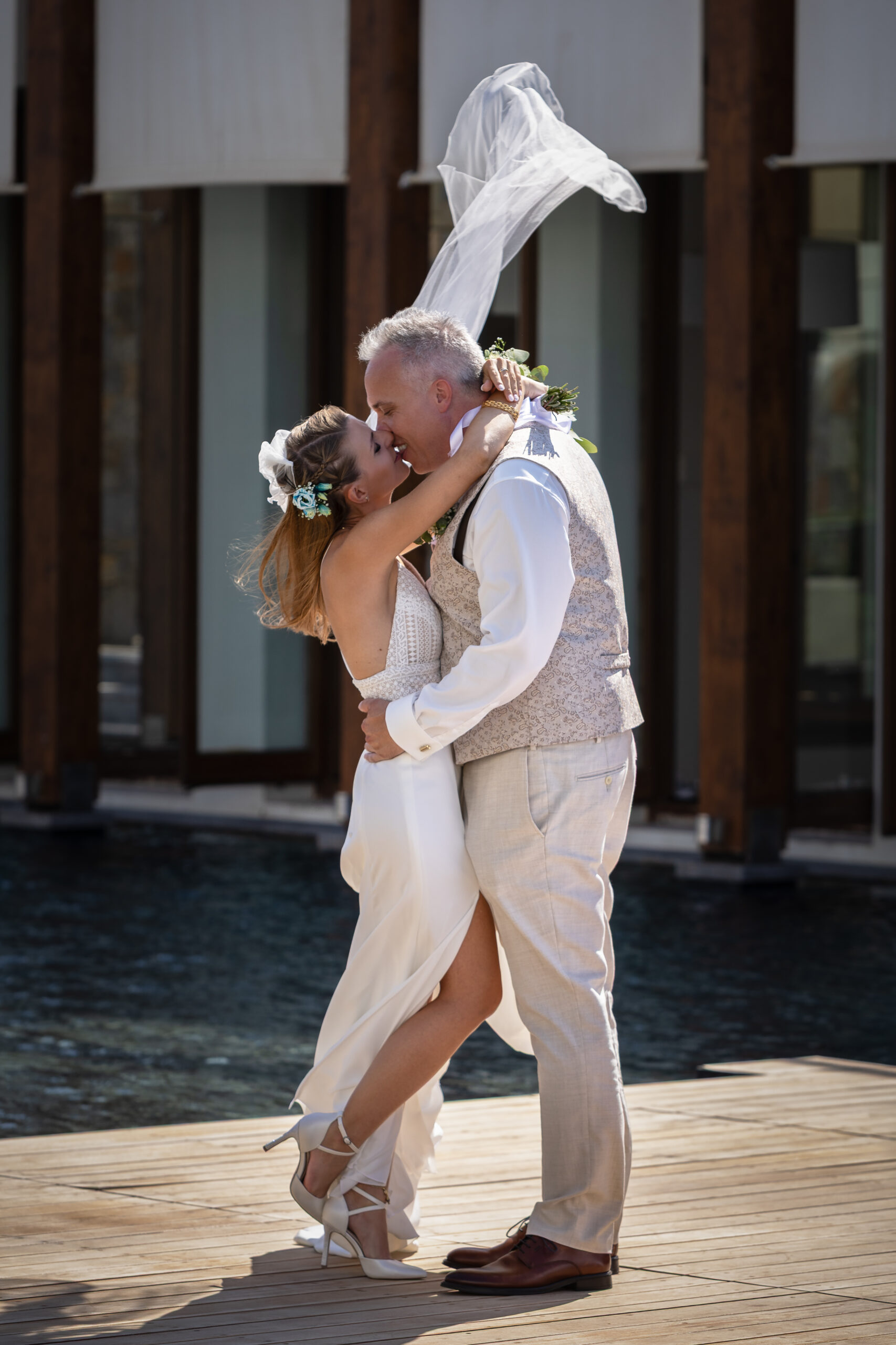 Paar küsst sich während der Hochzeit auf einem kleinen Steg im Wasser